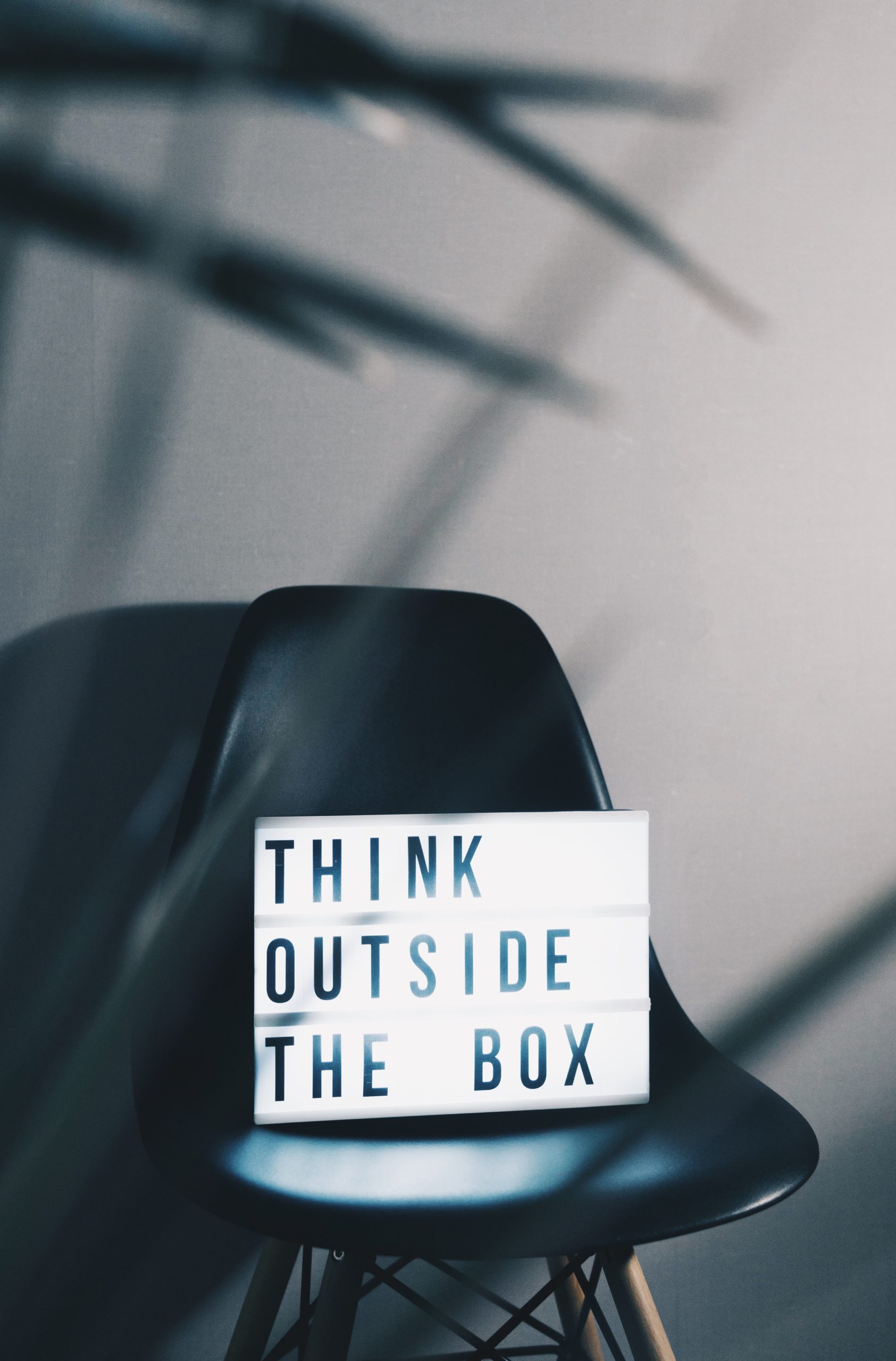 Sign sitting on a chair that says think outside the box